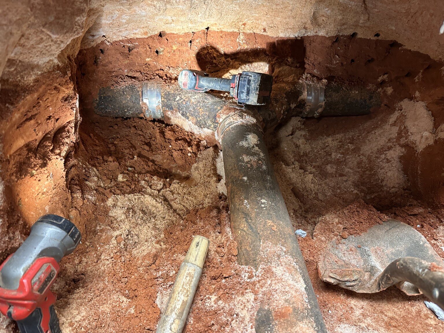 Exposed underground cast-iron drain piping during repair