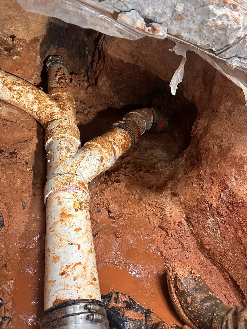 Drain piping exposed and prepared for replacement below a slab
